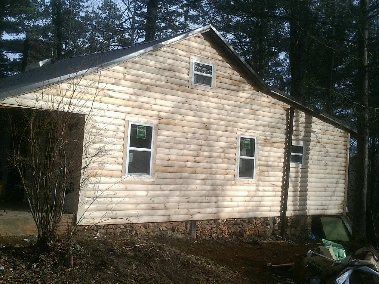New log siding and dark metal roofing on a gable end in Meridale