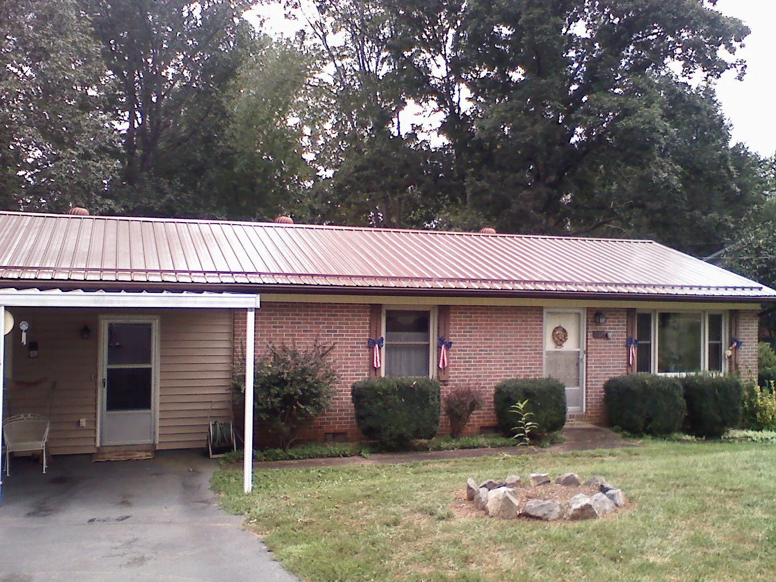 Bronze metal roof and carport on a brick ranch home — Roof Repair work by our crew in Meridale